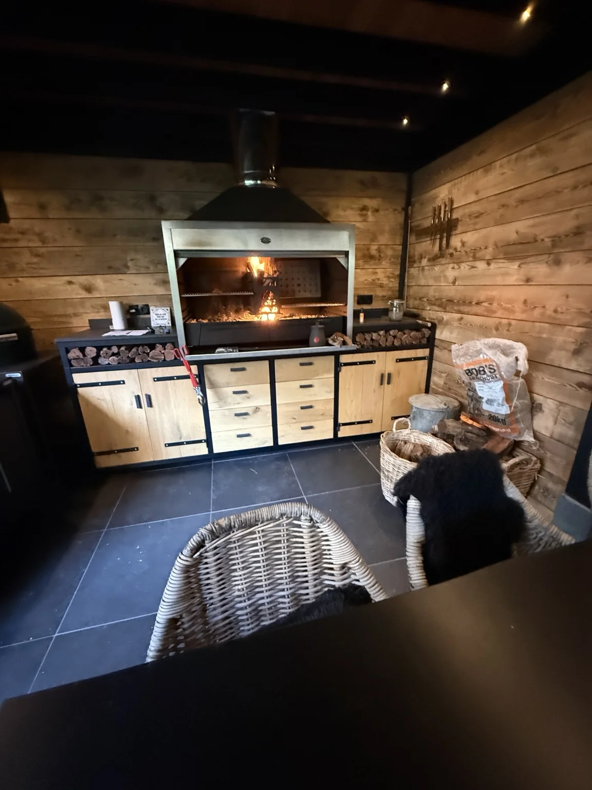 Bob’s Braaihut met een brandende braai, houten kasten en zitplaatsen
