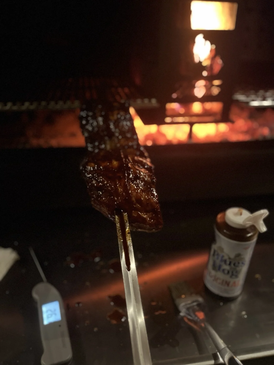 Spareribs op Bob’s braai met vuur op de achtergrond
